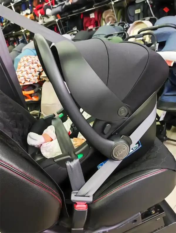 Infant car seat on a test bench with a mannequin in the correct rear-facing safety position