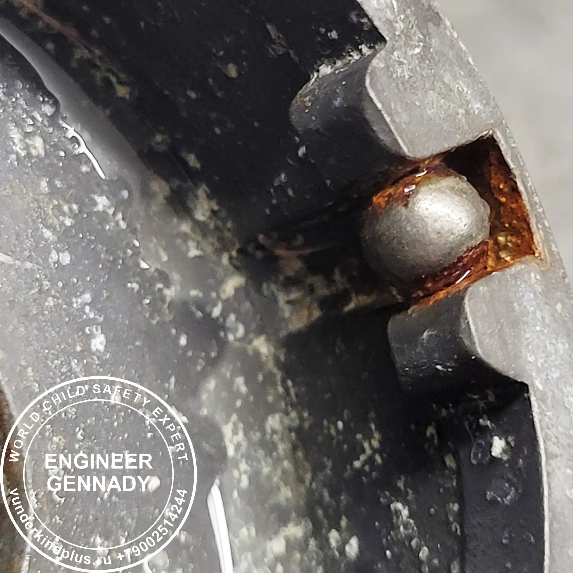 Macro shot of a single rusty bearing ball stuck inside a mechanism.